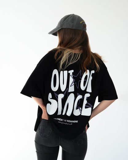 Schwarzes Oversize-T-Shirt, Rückenansicht: großer weißer Schriftzug „OUT OF SPACE“ über lila Stern-Umrissen; unten klein „CLOSEST TO NOWHERE – clothing from planet earth“.
