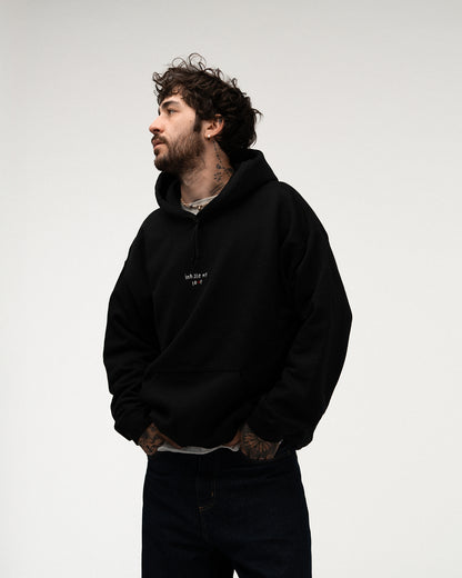 Schwarzer Hoodie mit Rückenmotiv aus weißen Linien in Herzform und dem Schriftzug „KEEP YOUR INNER PEACE – clothing from planet earth“, getragen von einer Person mit heller Schleife im Haar.

