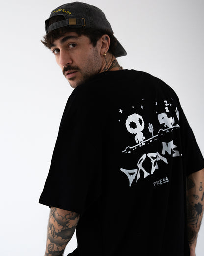 Detail Rückenprint, halbnahe Ansicht: weißer Pixel-Druck mit Totenkopf-Figur, Kaktus, Sternchen; großer Schriftzug „DREAMS“, darunter „PRESS START“; Druck mittig auf dem oberen Rücken platziert.