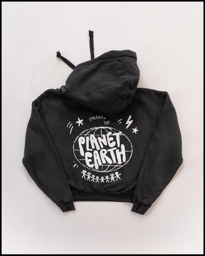 Schwarzer Hoodie mit weißem Aufdruck auf der Rückseite: „Children of Planet Earth“ in verspielter Schrift über einer stilisierten Weltkugel und einer Reihe von Strichmännchen. Lässiger, gemütlicher Stil mit Kapuze und Kordeln.